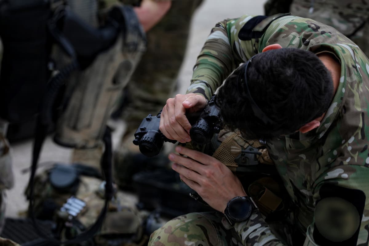 A Greek army soldier checking equipment before boarding training aboard a Greek navy ship