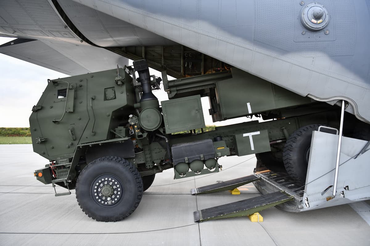 A Romanian Army HIMARS launcher backs into the cargo ramp of a U.S. Air Force MC-130J transport aircraft