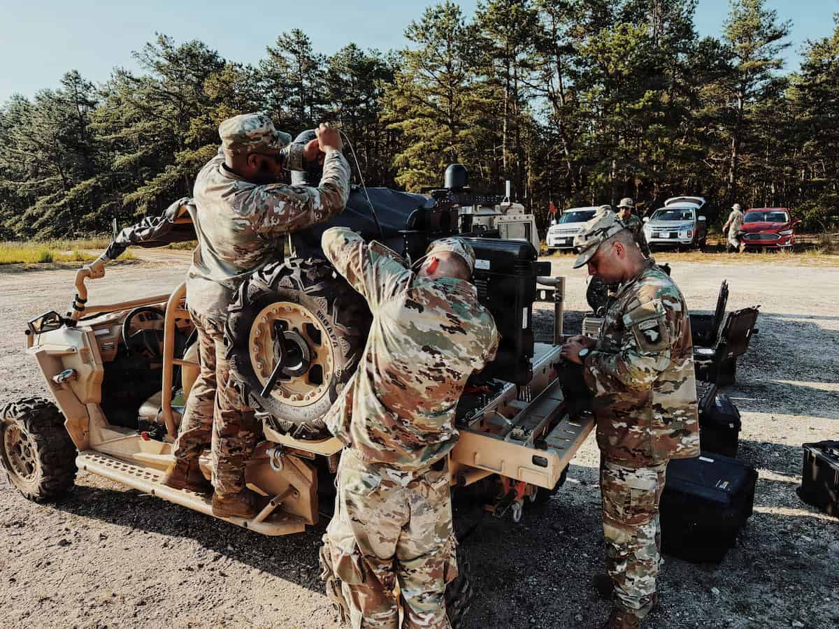 Three soldiers install Spectrum Situational Awareness System equipment on a light tactical vehicle