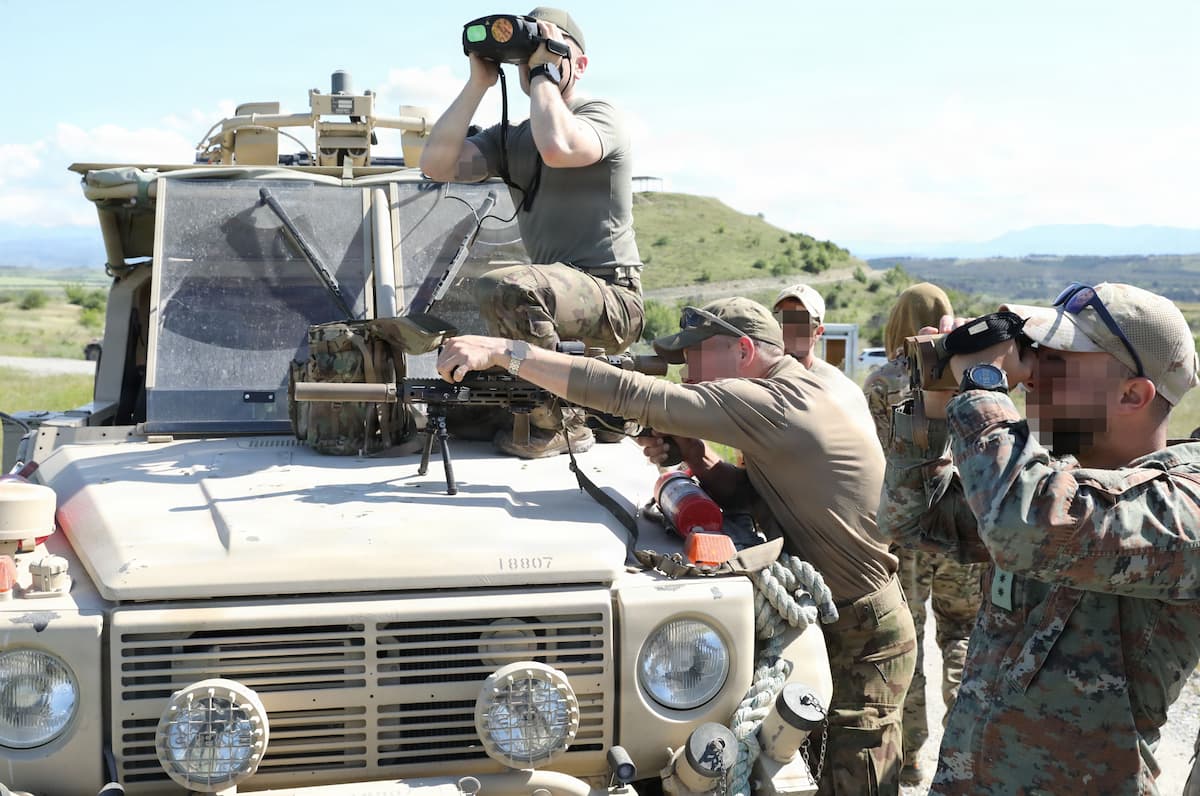 Swiss and North Macedonian special operations soldiers searching terrain during reconnaissance training